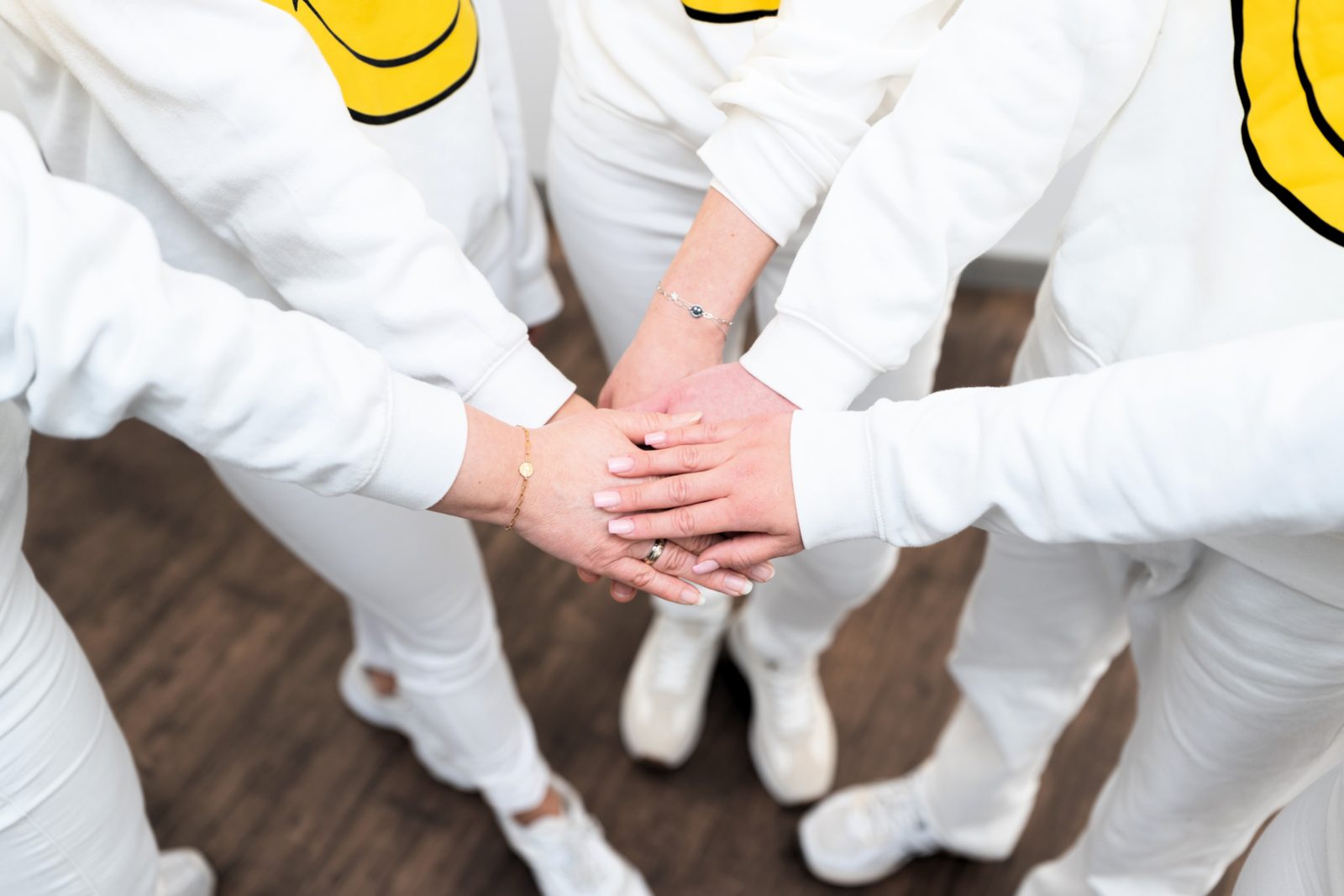 Das Team legt die Hände übereinander