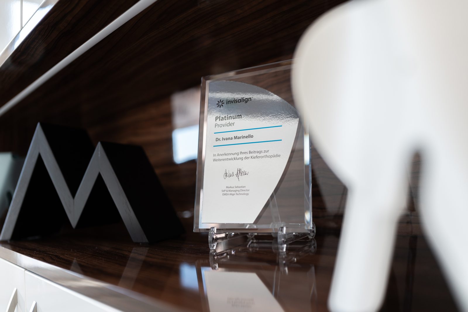 Auszeichnung als Invisalign Platinum Provider auf dem Empfangstresen